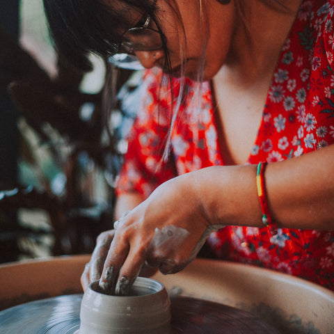 Person working with clay on a pottery wheel